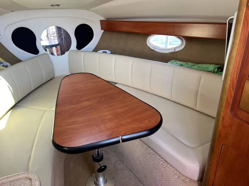 Slide: The Image of Interior of 2008 Rinker 260 Express Cruiser with beige seating and wooden table. - 20