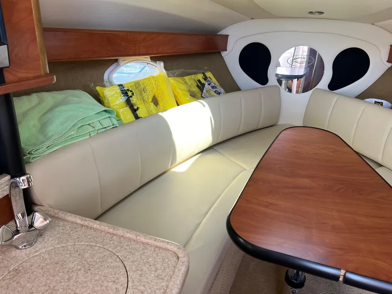 Slide: The Image of Interior of 2008 Rinker 260 Express Cruiser with beige seating and wooden table. - 21