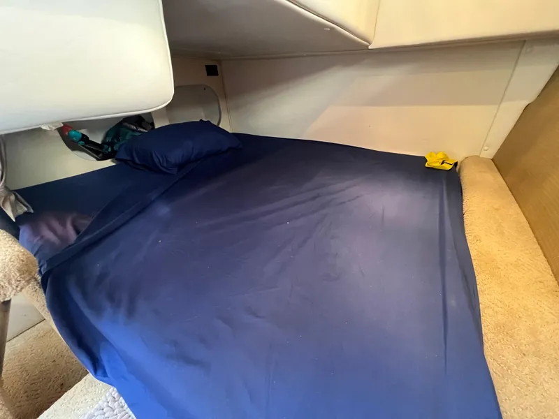 Slide: The Image of Interior cabin of 2008 Rinker 260 Express Cruiser with blue bedding. - 26