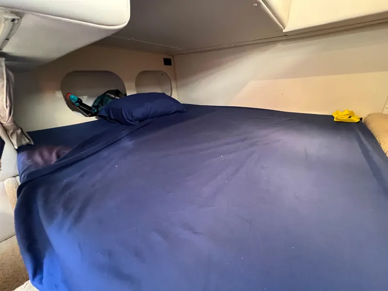 Slide: The Image of 2008 Rinker 260 Express Cruiser cabin with blue bedding and cozy interior. - 27