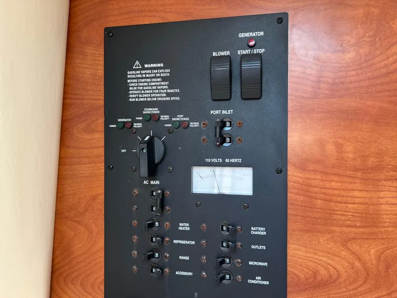 Slide: The Image of Control panel of a 2008 Rinker 260 Express Cruiser with generator switches. - 28