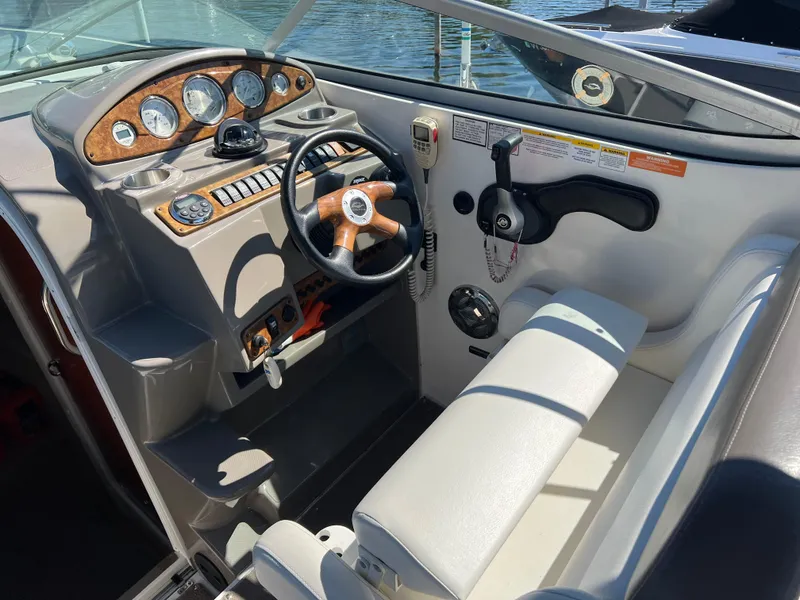Slide: The Image of 2008 Rinker 260 Express Cruiser helm with wood accents and white seating. - 8