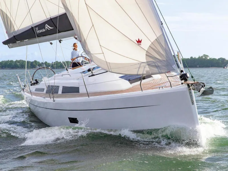 Slide: The Image of 2025 Hanse 348 sailboat navigating through water with full sails. - 1