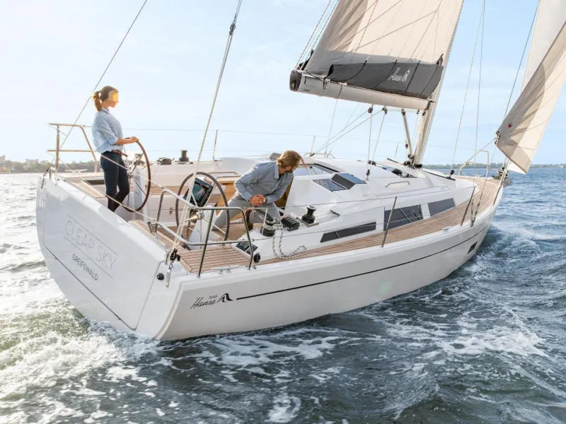 Slide: The Image of 2025 Hanse 348 sailboat navigating ocean waters with two people onboard. - 0