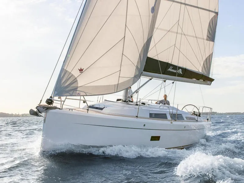 Slide: The Image of 2025 Hanse 348 sailboat navigating ocean waves under full sail. - 2
