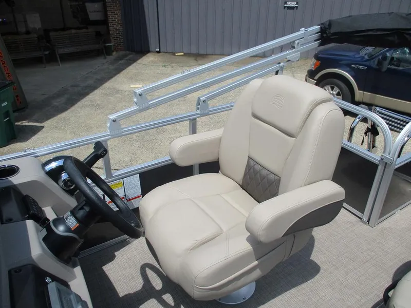 Slide: The Image of 2024 Sun Tracker PARTY BARGE® 18 DLX captain's chair, beige upholstery, boat interior. - 6