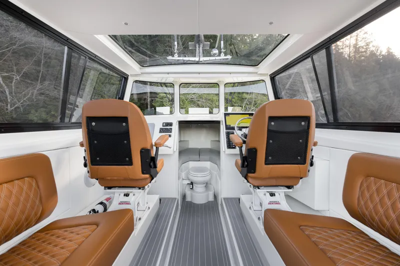 Slide: The Image of Interior of 2026 Jasper Marine Defender 22 boat with brown leather seats and modern controls. - 19