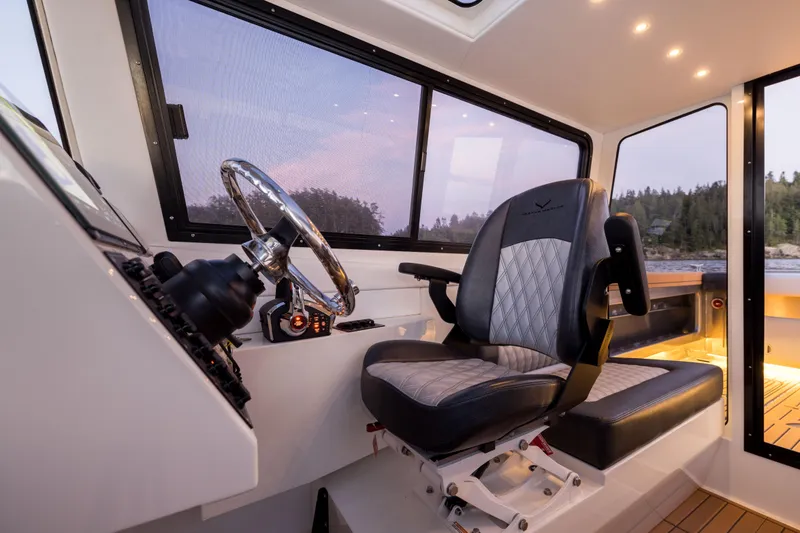 Slide: The Image of Interior of 2026 Jasper Marine Defender 22 boat with steering wheel and captain's chair. - 37