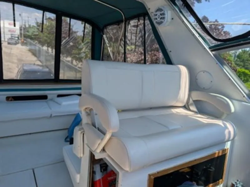 Slide: The Image of 1989 Sea Ray 390 Express Cruiser interior with white seating and large windows. - 10