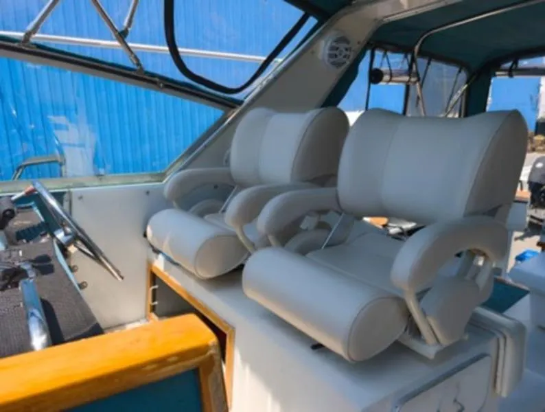 Slide: The Image of 1989 Sea Ray 390 Express Cruiser helm with dual white captain chairs. - 11