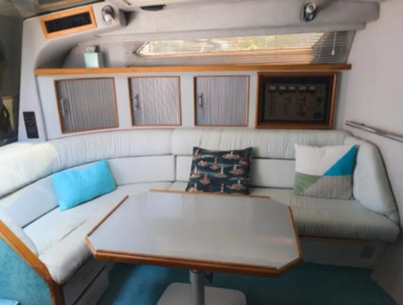 Slide: The Image of Interior of 1989 Sea Ray 390 Express Cruiser with cozy seating and table. - 13