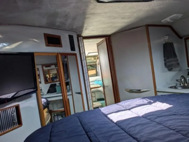 Slide: The Image of Interior of 1989 Sea Ray 390 Express Cruiser with bed, TV, and bathroom. - 15