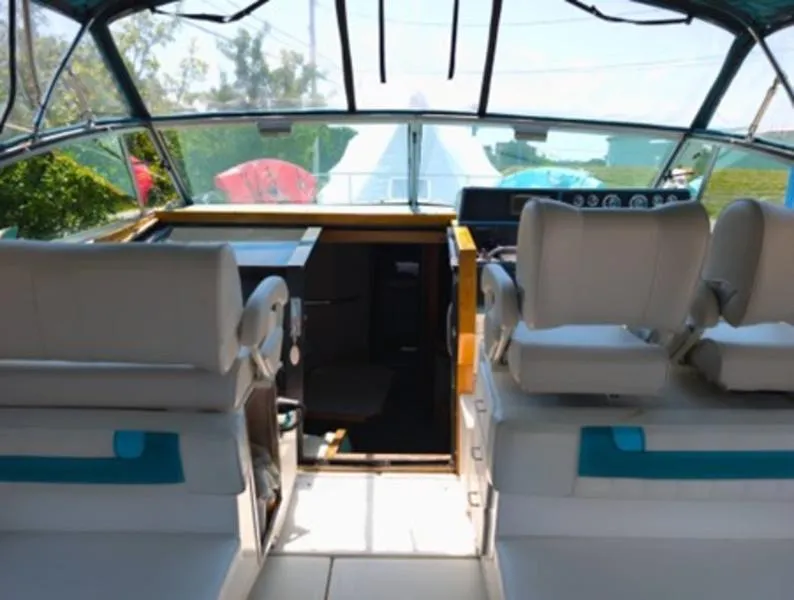 Slide: The Image of 1989 Sea Ray 390 Express Cruiser cockpit with white seating and dashboard view. - 18