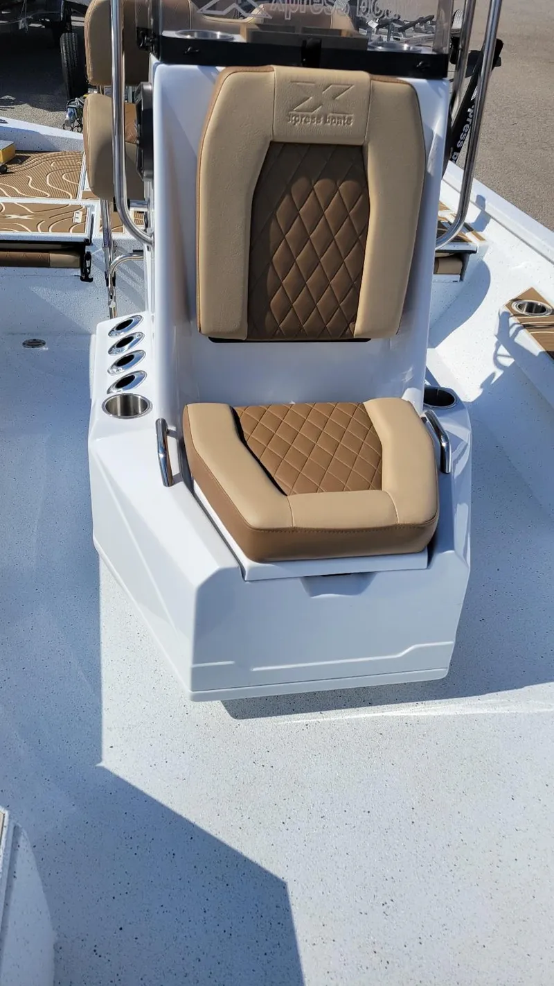 Slide: The Image of 2025 Xpress H22 Bay boat seat with tan upholstery and cup holders. - 15