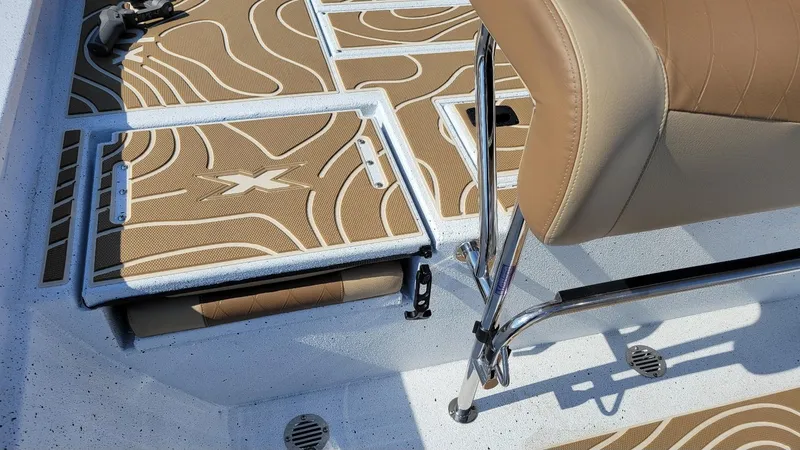 Slide: The Image of 2025 Xpress H22 Bay boat interior with tan seating and patterned flooring. - 17