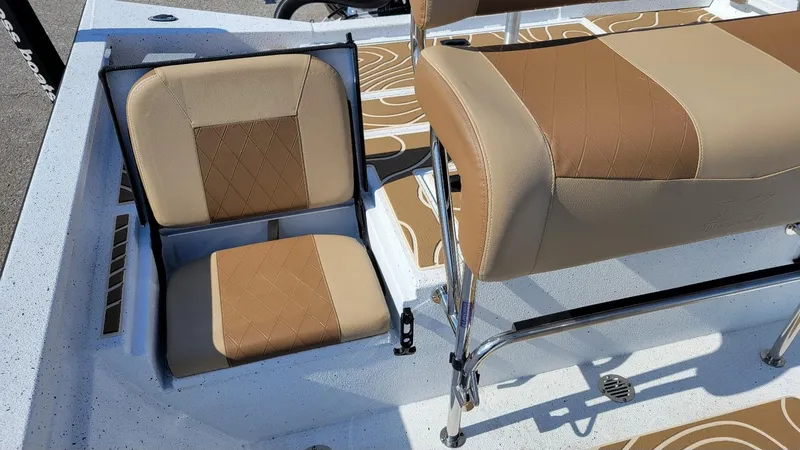 Slide: The Image of 2025 Xpress H22 Bay boat seating with tan upholstery and storage compartment. - 18