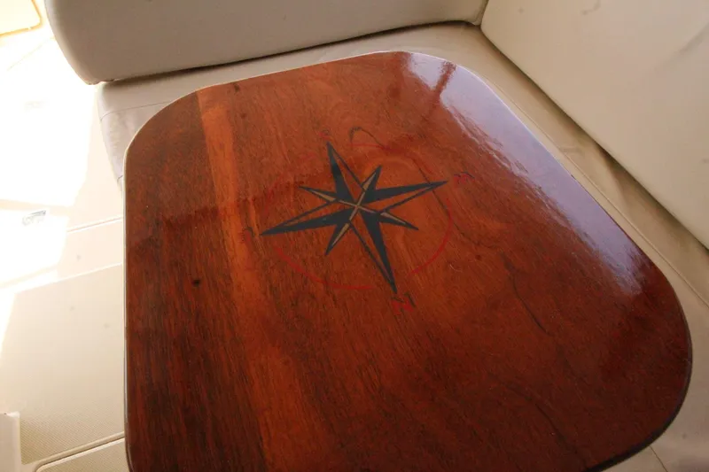 Slide: The Image of Wooden table with compass rose on Island Packet 360, 2002 model. - 12