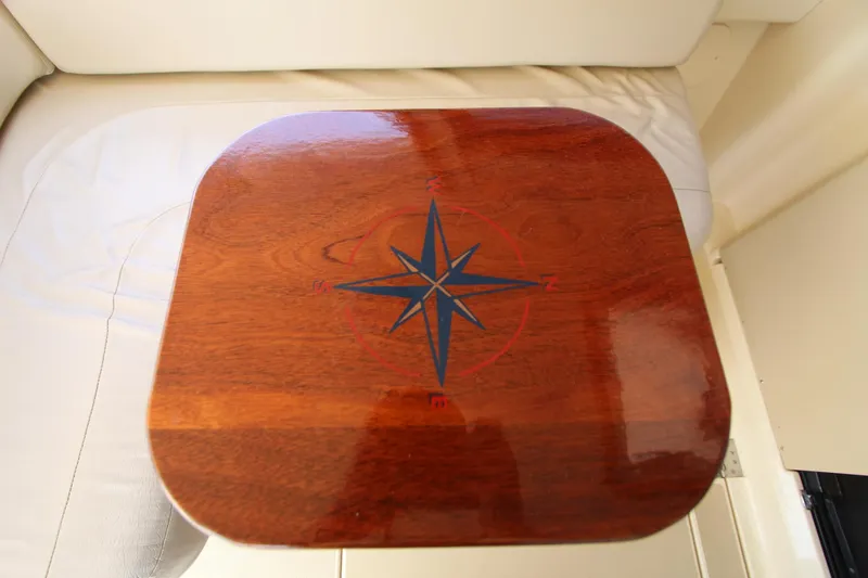 Slide: The Image of Wooden table with compass design on Island Packet 360, 2002 model. - 8