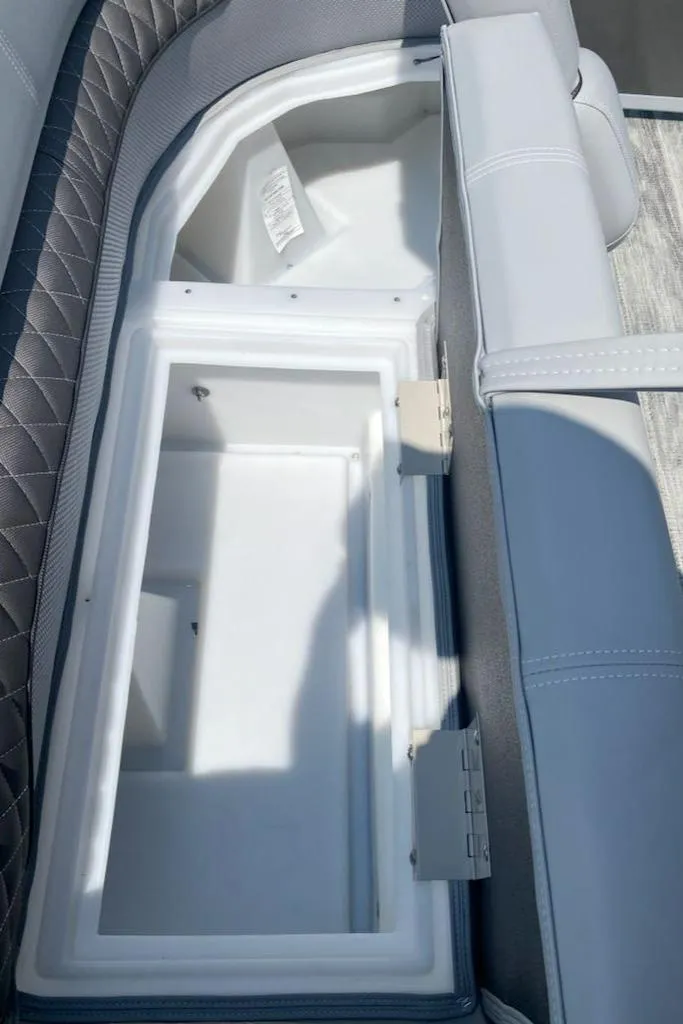 Slide: The Image of 2024 Ranger Reata 223C boat storage compartment with cushioned seating. - 11