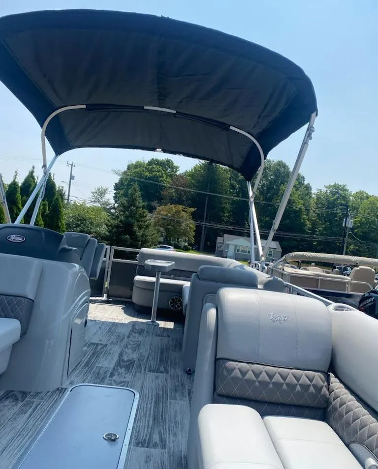 Slide: The Image of 2024 Ranger Reata 223C pontoon boat with spacious seating and canopy. - 14