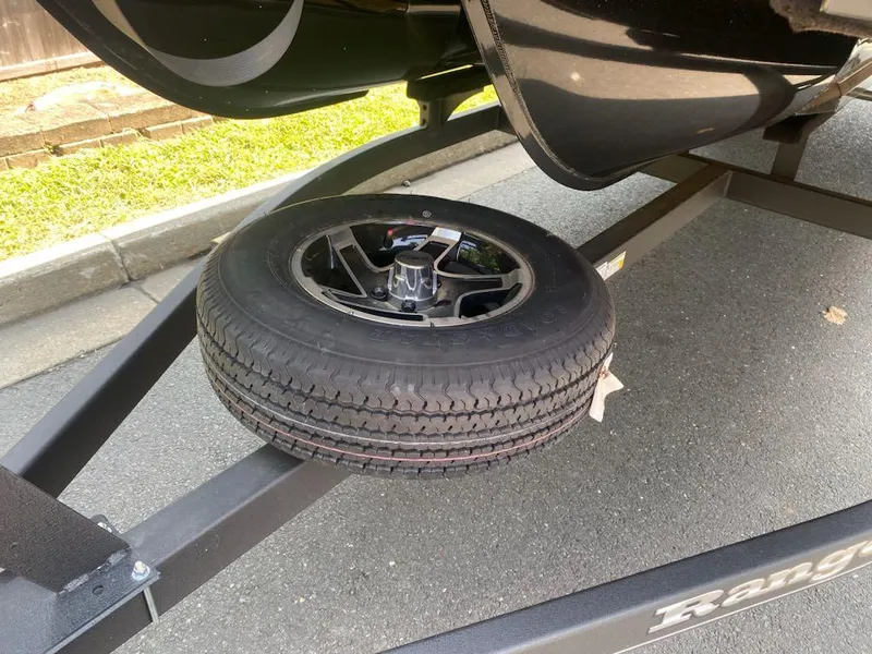 Slide: The Image of 2024 Ranger Reata 223C trailer with spare tire on pavement. - 16