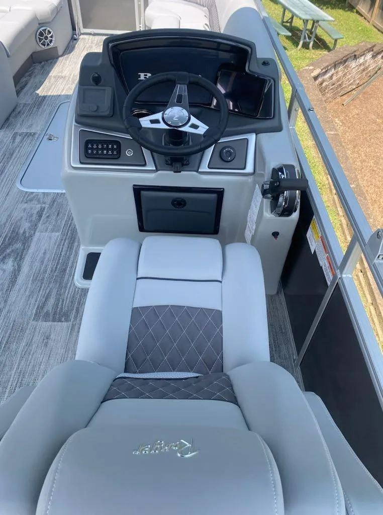 Slide: The Image of 2024 Ranger Reata 223C boat cockpit with modern steering and seating. - 7