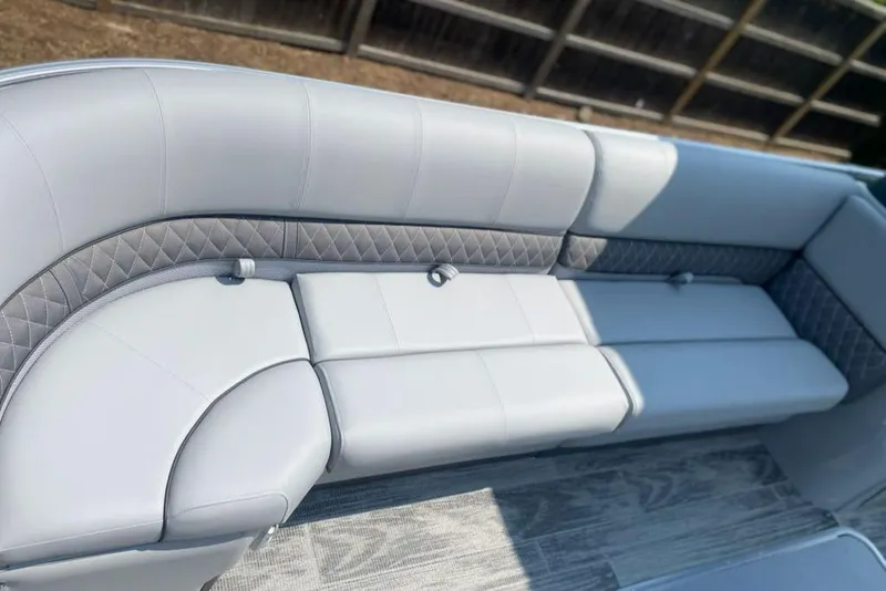Slide: The Image of 2024 Ranger Reata 223C boat interior with plush gray seating and quilted accents. - 8