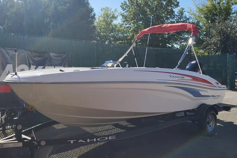 Slide: The Image of 2024 Tahoe T18 boat with red canopy on trailer, outdoors. - 2