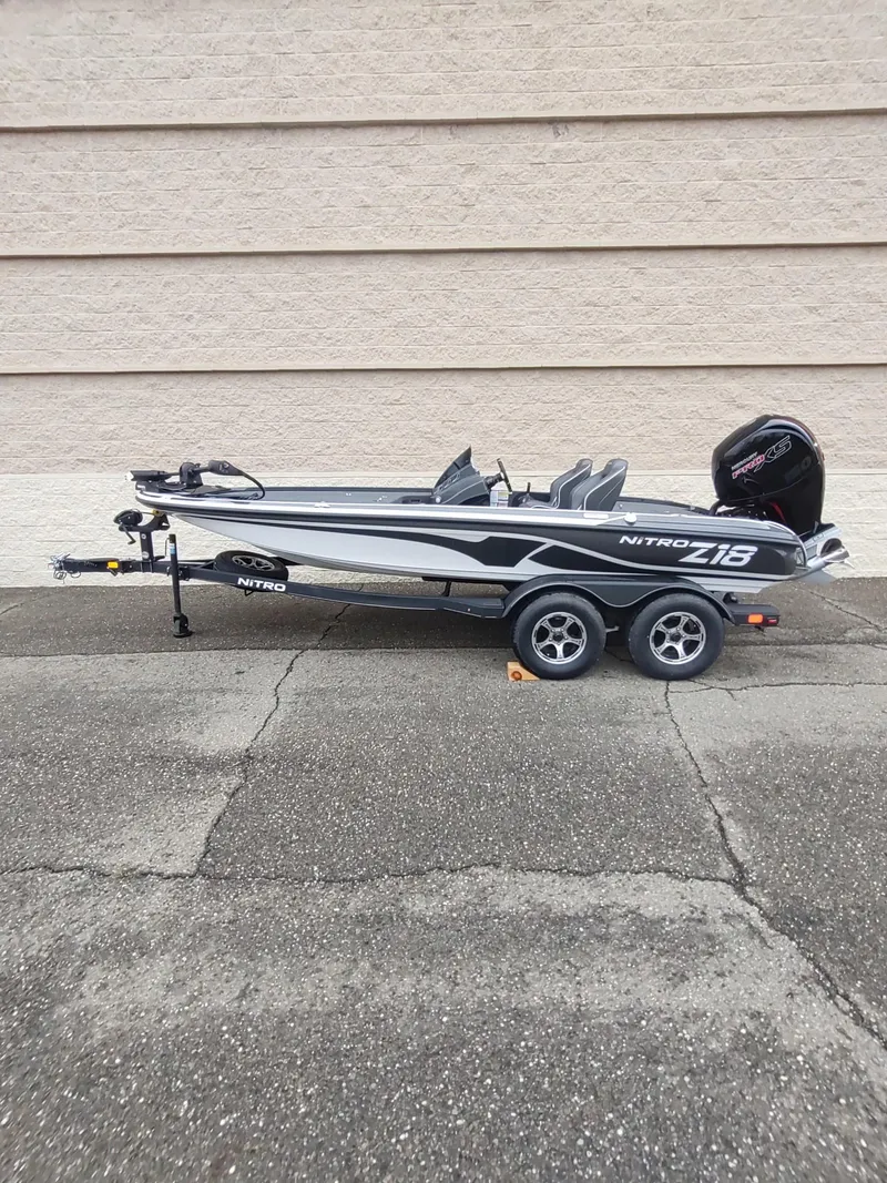 Slide: The Image of 2024 Nitro Z18 boat on trailer, parked against a beige wall. - 0