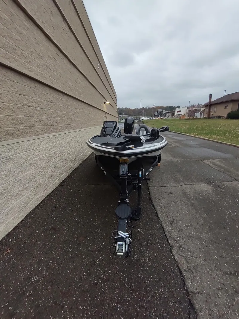 Slide: The Image of 2024 Nitro Z18 boat parked on a paved driveway beside a building. - 2
