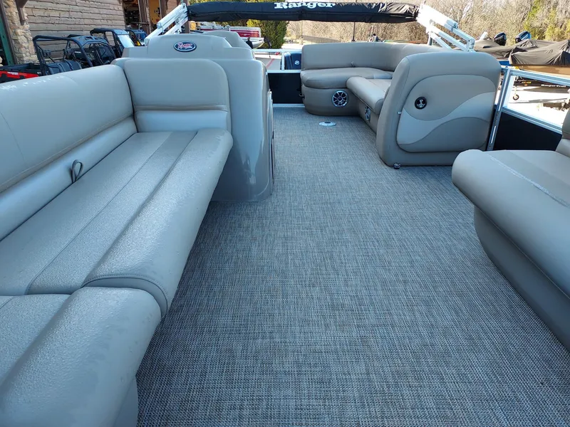 Slide: The Image of 2024 Ranger Reata 200C pontoon boat interior with gray seating and carpet flooring. - 2
