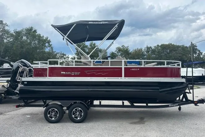 The Image of 2024 Ranger Reata 200F pontoon boat with canopy on trailer, parked outdoors. - 0