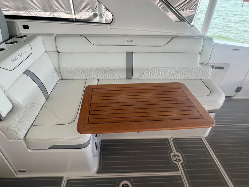 Slide: The Image of Luxurious seating area on a 2022 Regal LS36 boat with a wooden table. - 14
