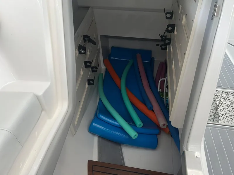 Slide: The Image of Storage compartment in a 2022 Regal LS36 boat with colorful pool noodles and mats. - 29