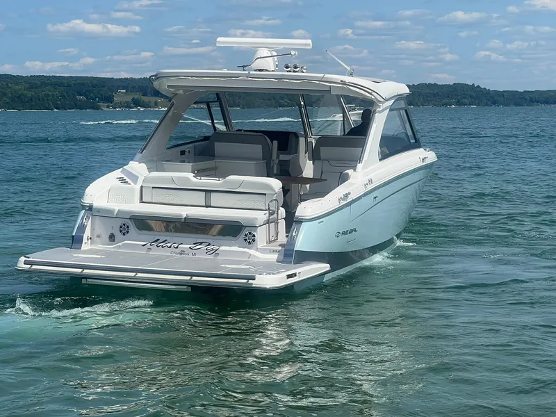 Slide: The Image of 2022 Regal LS36 boat cruising on a clear lake under a blue sky. - 36
