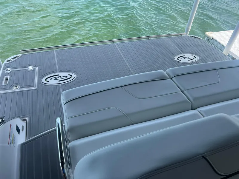 Slide: The Image of 2022 Regal LS36 boat deck with cushioned seating, overlooking calm water. - 7