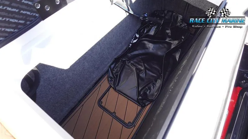 Slide: The Image of 2025 Nautique Super Air Nautique GS22 storage compartment with black bag and Race City Marine logo. - 15