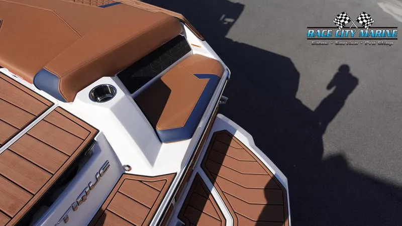 Slide: The Image of 2025 Nautique Super Air Nautique GS22 boat with brown and white deck, Race City Marine logo. - 43