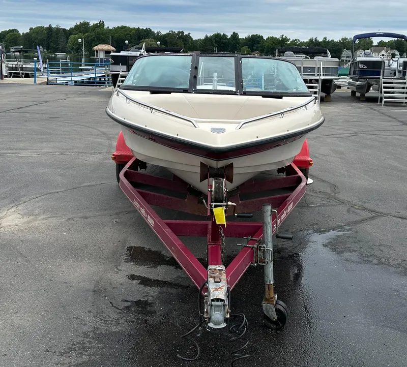 Slide: The Image of 2000 Malibu Response LXi boat on a red trailer in a marina parking lot. - 2