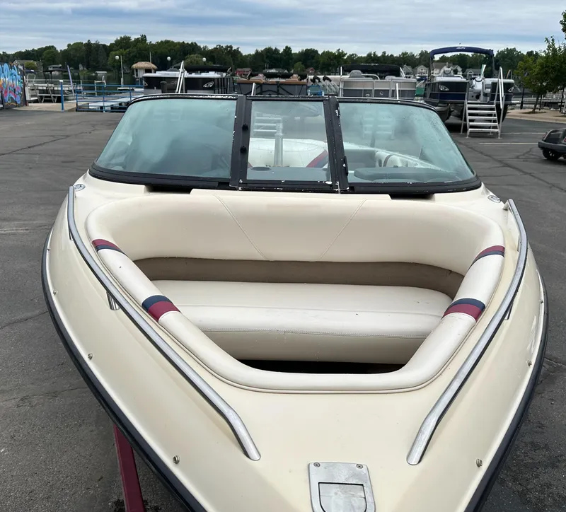 Slide: The Image of 2000 Malibu Response LXi boat with white seating, parked at a marina. - 3