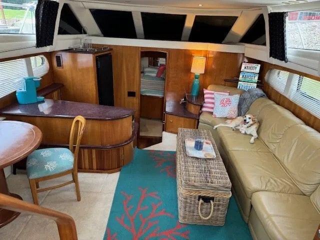 Slide: The Image of Interior of 2001 Carver 396 Motoryacht with cozy seating, decor, and a small dog. - 4
