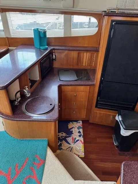 Slide: The Image of Interior of 2001 Carver 396 Motoryacht kitchen with wood cabinetry and modern appliances. - 5