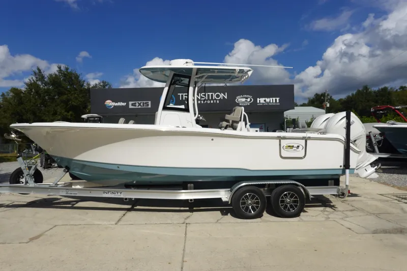 The Image of 2025 Sea Hunt Ultra 265 SE boat on trailer, displayed outdoors under blue sky. - 1