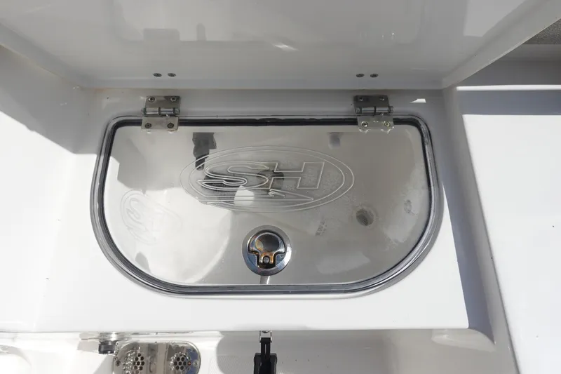Slide: The Image of 2025 Sea Hunt Ultra 265 SE boat compartment with SH logo and latch. - 13