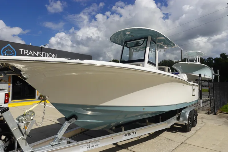 Slide: The Image of 2025 Sea Hunt Ultra 265 SE boat on trailer at dealership under cloudy sky. - 2