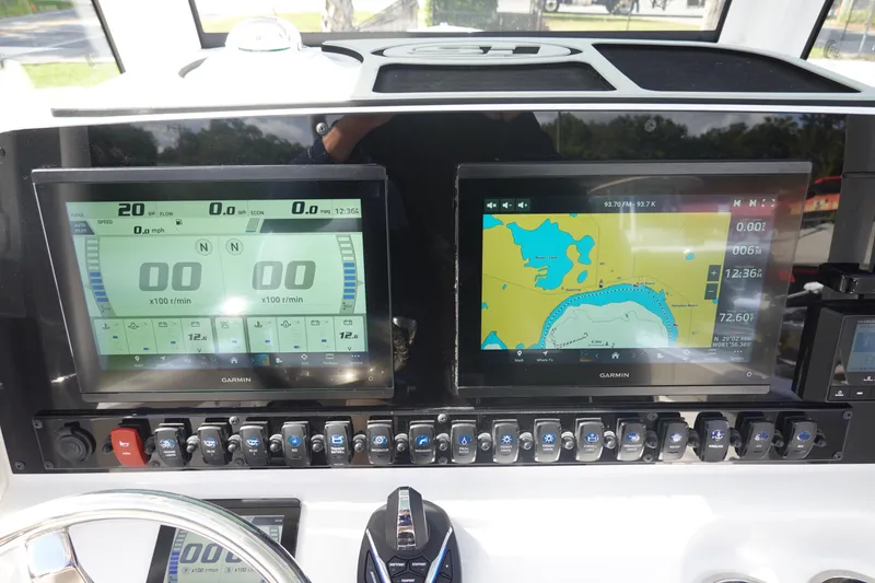 Slide: The Image of Dashboard of 2025 Sea Hunt Ultra 265 SE with Garmin navigation displays and control switches. - 25