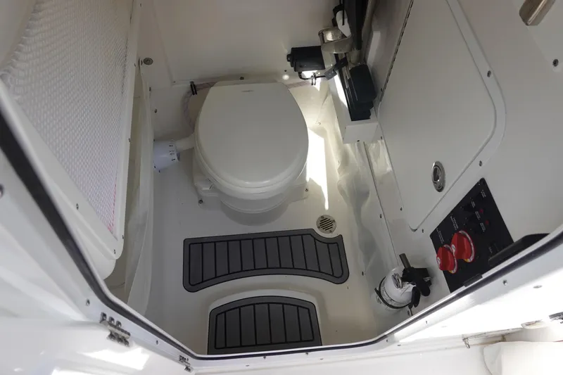 Slide: The Image of Interior of 2025 Sea Hunt Ultra 265 SE boat, featuring a compact marine toilet. - 40