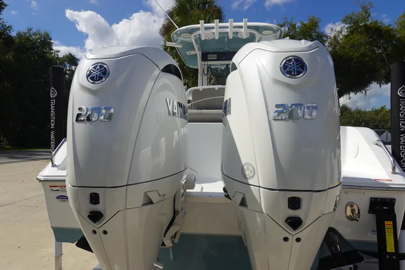 Slide: The Image of 2025 Sea Hunt Ultra 265 SE with twin Yamaha 200 engines, parked outdoors. - 7