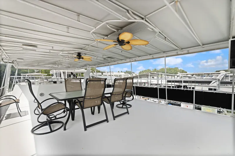 Slide: The Image of Spacious deck of 2001 Stardust Cruisers houseboat with outdoor dining set and ceiling fans. - 10