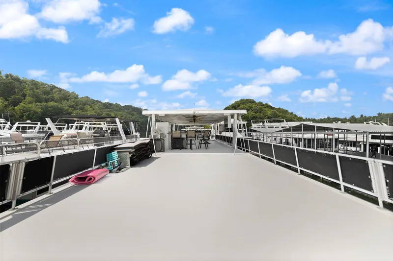 Slide: The Image of 2001 Stardust Cruisers houseboat deck with seating, under clear blue sky. - 13